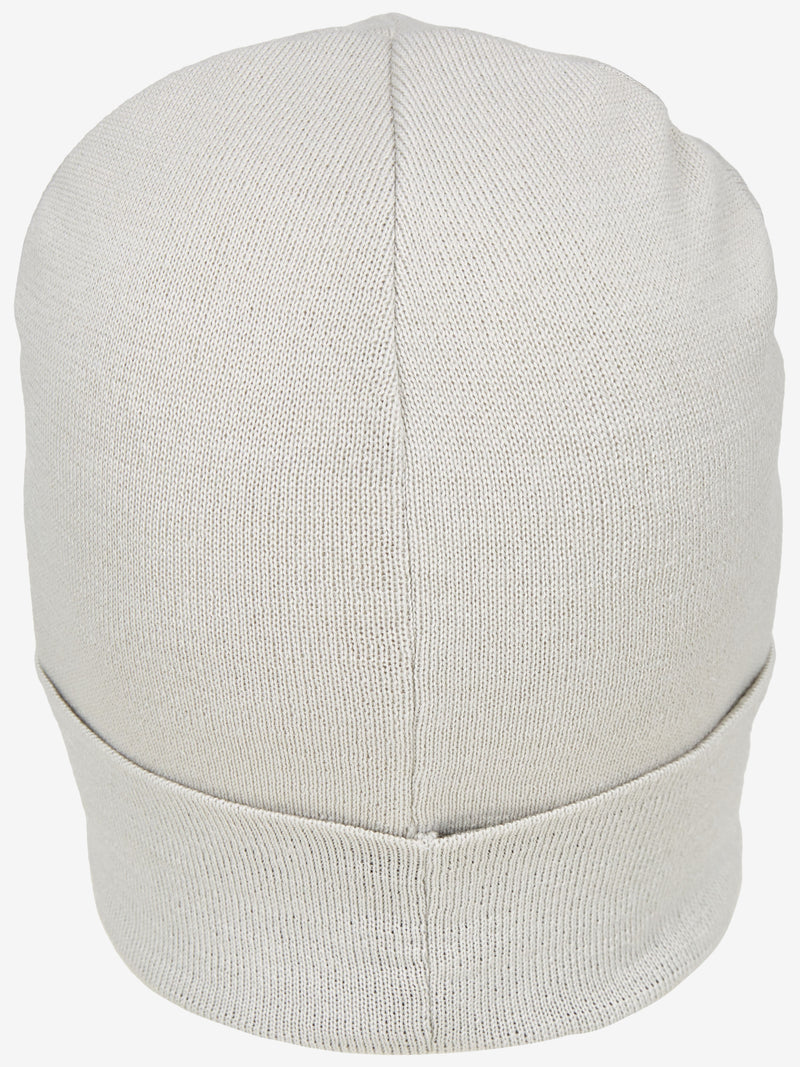 Weiße, elastische Beanie-Mütze aus gestricktem Material, die eng am Kopf sitzt und auch bei kaltem Wetter für Wärme sorgt.
