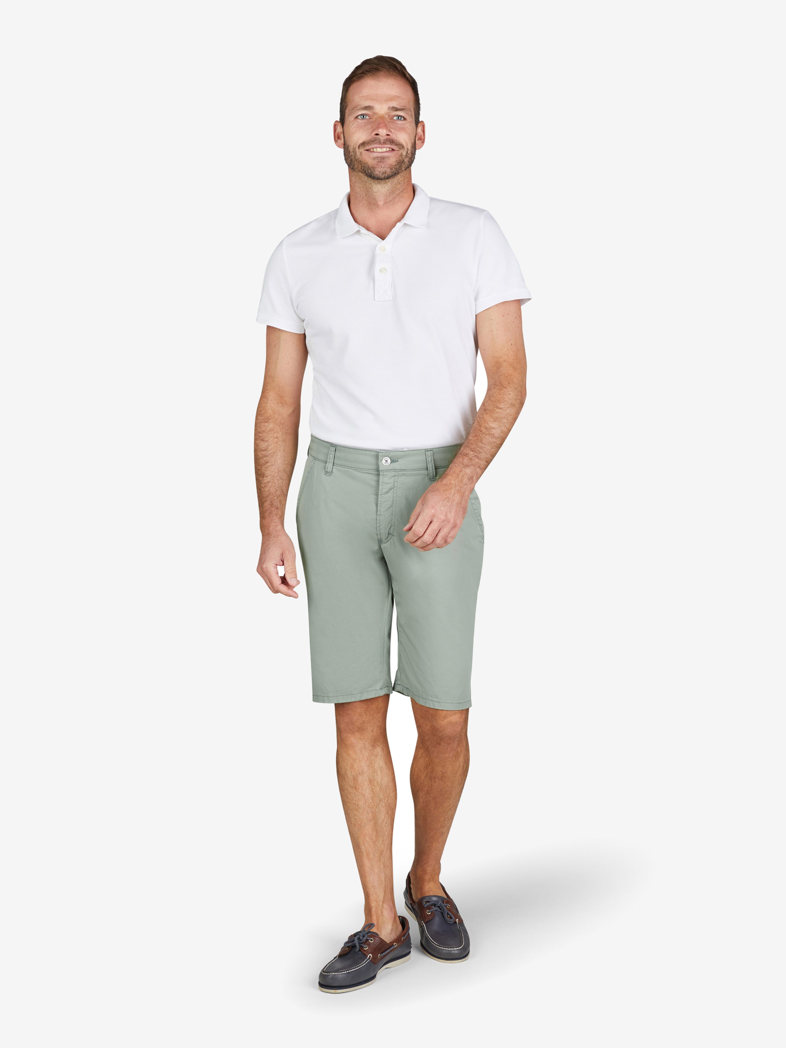 Mann trägt Weißes Polo-Shirt und hellgrüne Bermuda-Shorts mit elastischem Komfortbund, Hemdenstopper, High Stretch, aus Baumwoll-Tencel®-Mix, normaler Leibhöhe, Modell ESPANA 8109, Hersteller Club of Comfort, Frühling/Sommer, grüne Farbfamilie, modebewusst, bequem.