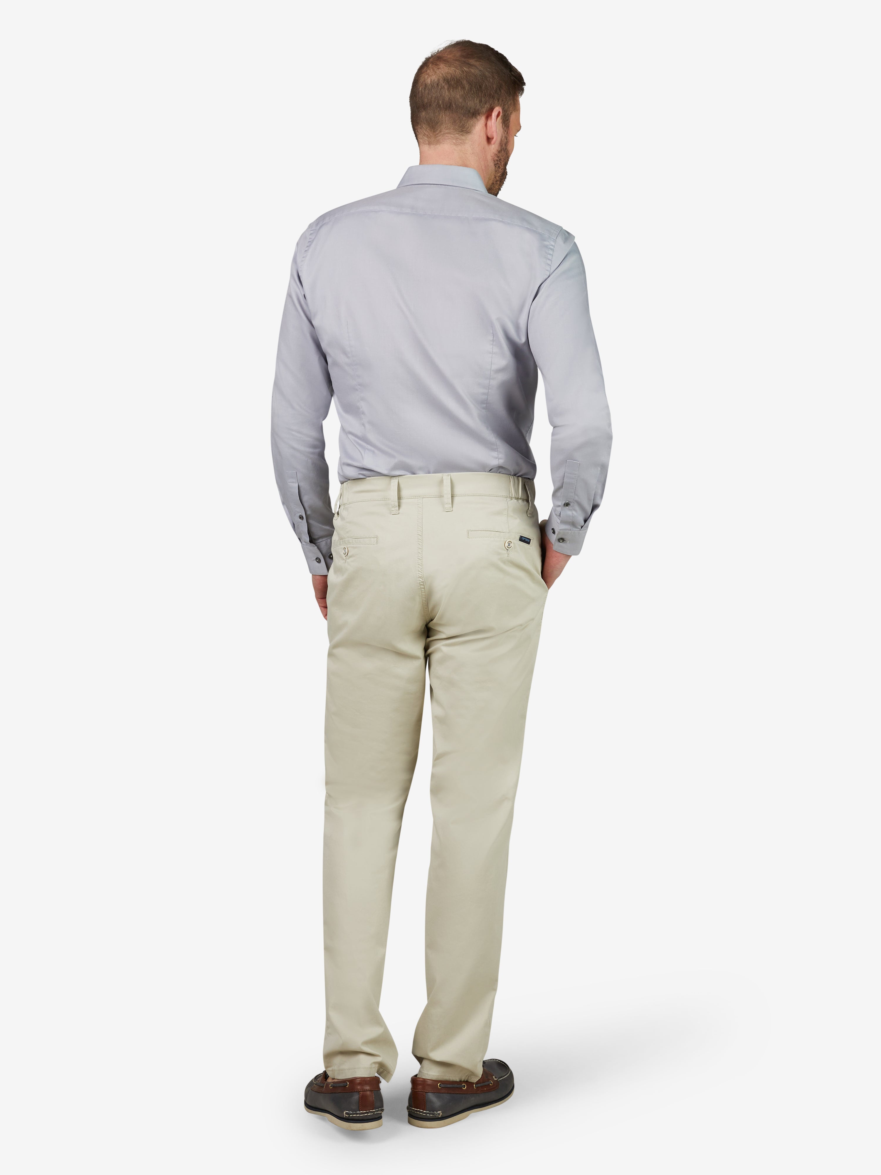 Westenansicht eines Mannes, der eine beige FOXX 8170 Chino-Hose mit slim Fit trägt, aus sommerleichter Baumwolle mit hohem Stretch-Anteil. Die Hose hat einen Comfort-Flex-Bund, Hemdenstopper, normale Leibhöhe, schmale Beinweite und ist von Club of Comfort.