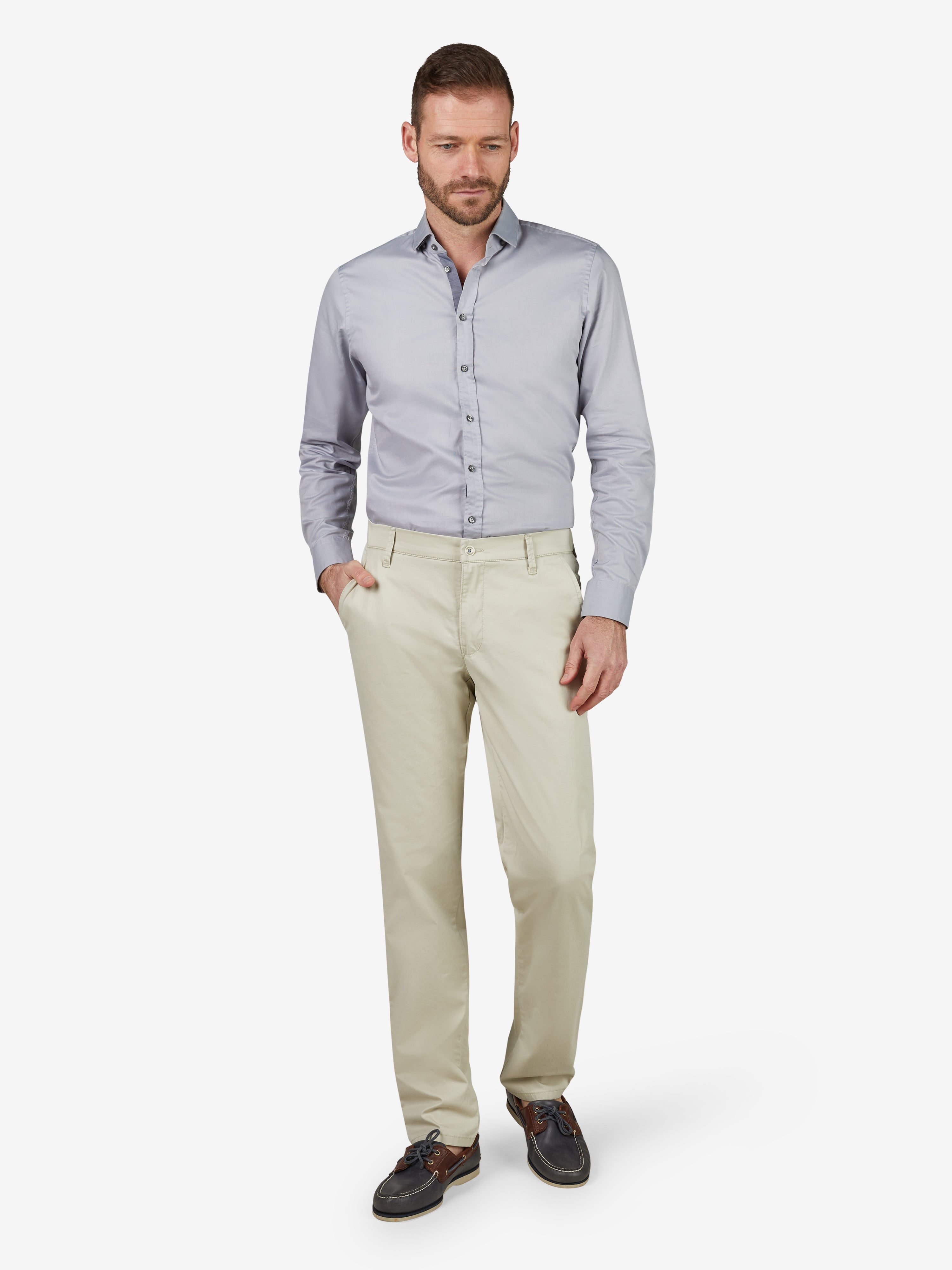 Mann in hellbeiger Chino/Flat Front Hose FOXX 8170 von Club of Comfort mit normaler Leibhöhe, schlankem Bein, Slim Fit, Hemdstopper, Comfort-Flex-Bund und High Stretch Baumwolle, getragen im Frühjahr/Sommer.