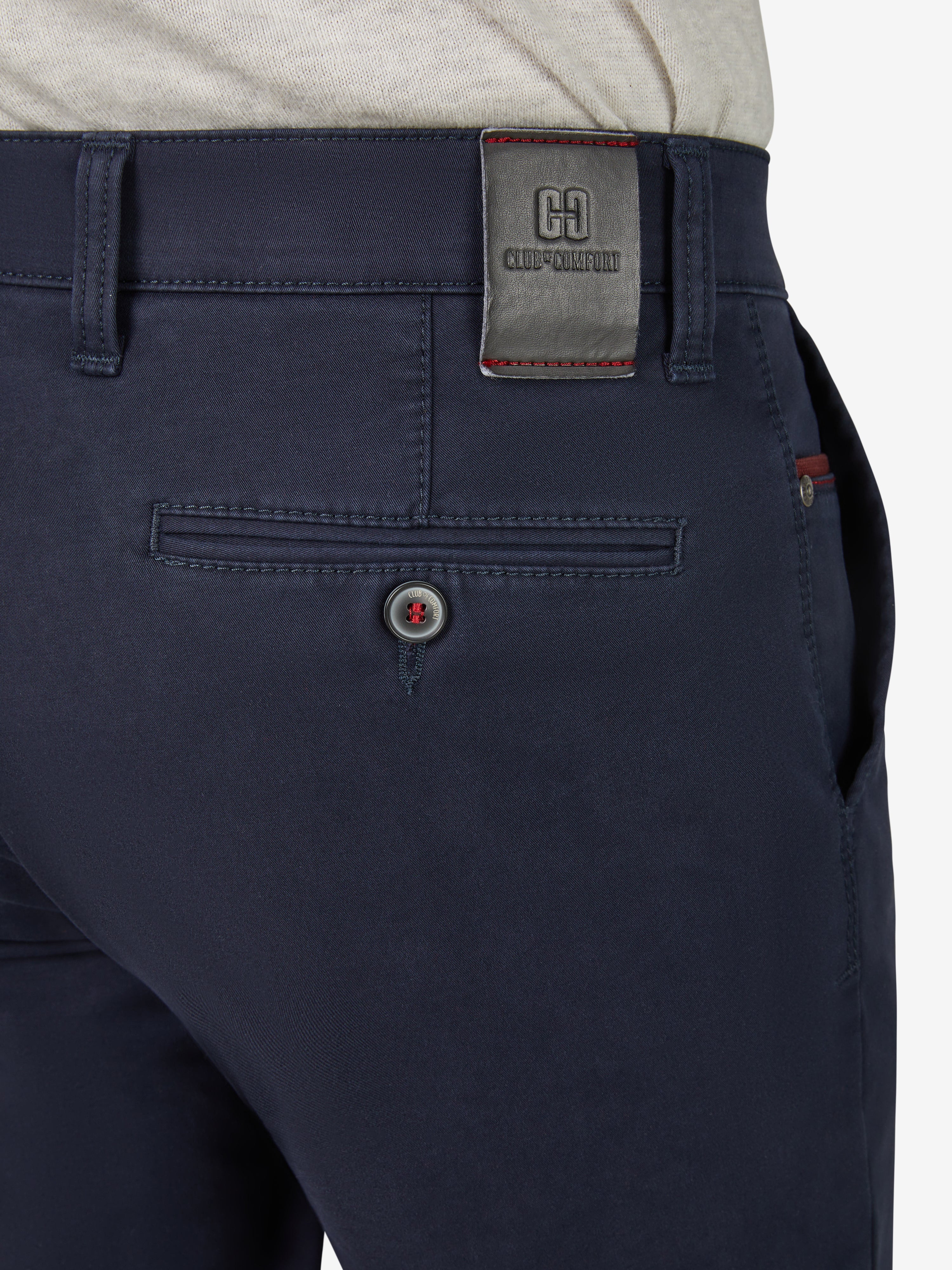 Nahaufnahme einer enganliegenden, marineblauen Flat-Front-Hose mit Komfortbund von Club of Comfort, mit Hemdstopper, Münztasche in rechter Seitentasche, aus High Stretch-Baumwolle mit Thermolite-Wärmeisolierung, sichtbarem Markenetikett am Gürtel, für Herbst/Winter, schlanker Beinverlauf und deutsches Größensystem.