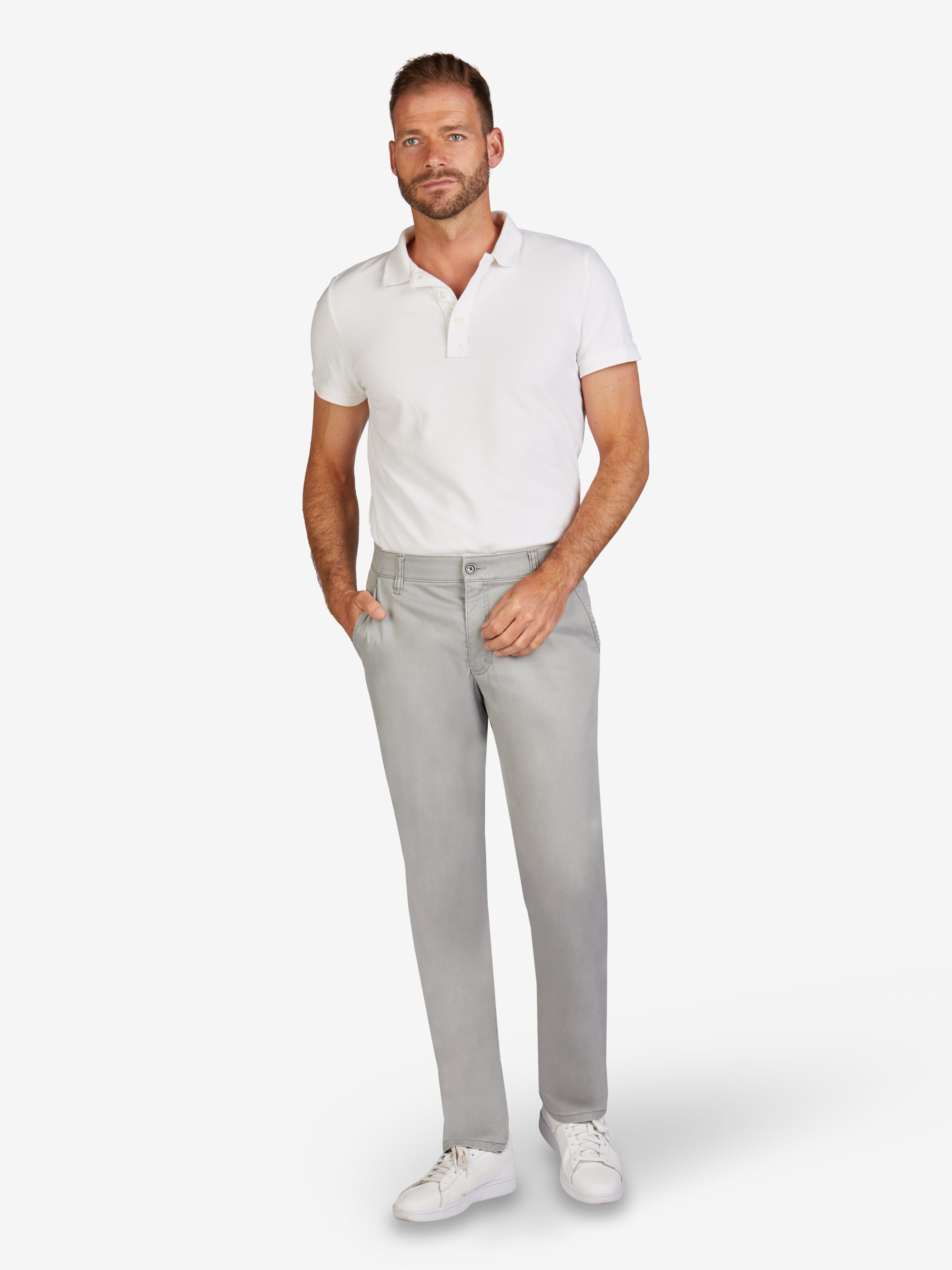 Mann trägt hellgraue GARVEY 6701 Flat Front-Hose aus Baumwoll-Broken-Twill mit High Stretch, sportiven Seitentaschen, Komfortbund, Hemdenstopper, reguläre Leibhöhe, schmaler Beinverlauf, im Frühjahr/Sommer-Look, model with weißen Shirt und Sneakers.