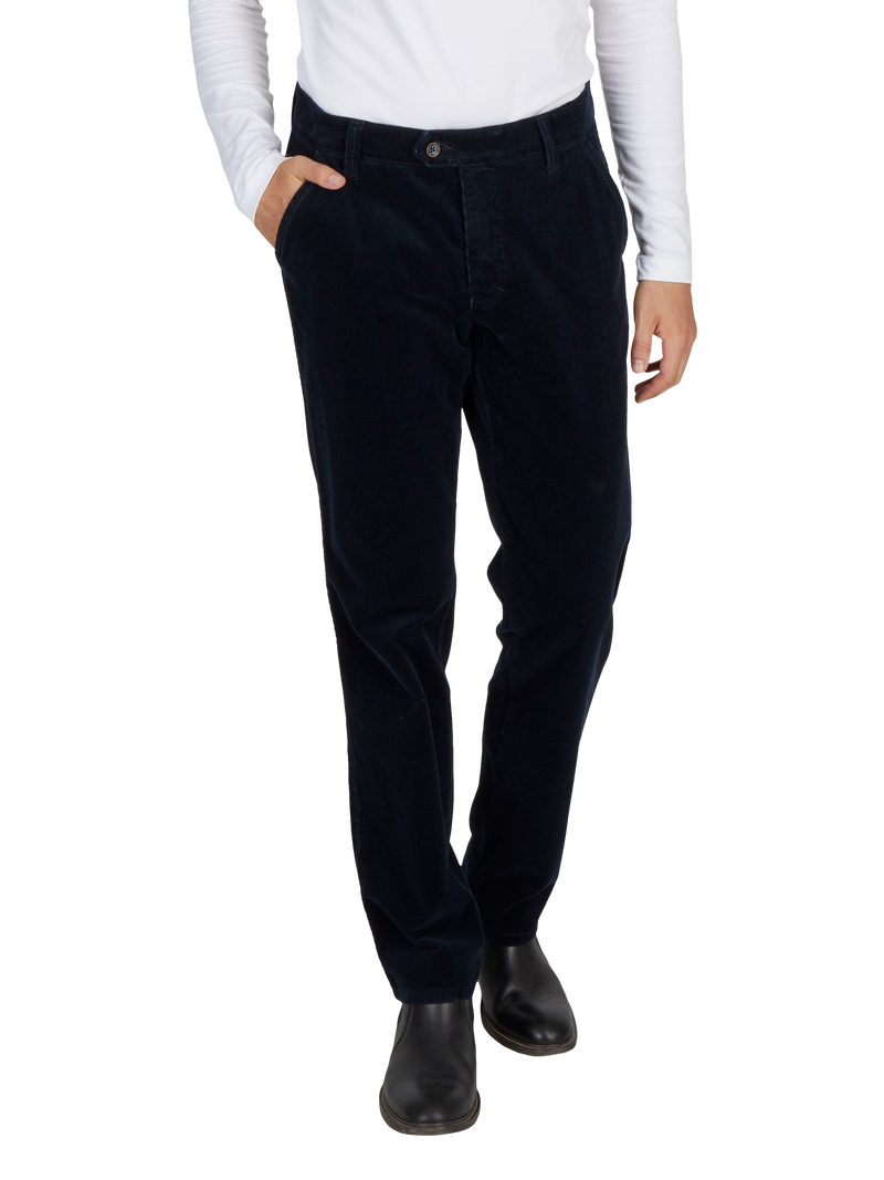 Hosenmodell aus dunkelblauem, locker sitzendem Stoff, mit Gürtelschlaufen, Seitentaschen und einer Knopfleiste. Die Person trägt dazu schwarze Schuhe und ein weißes Oberteil.