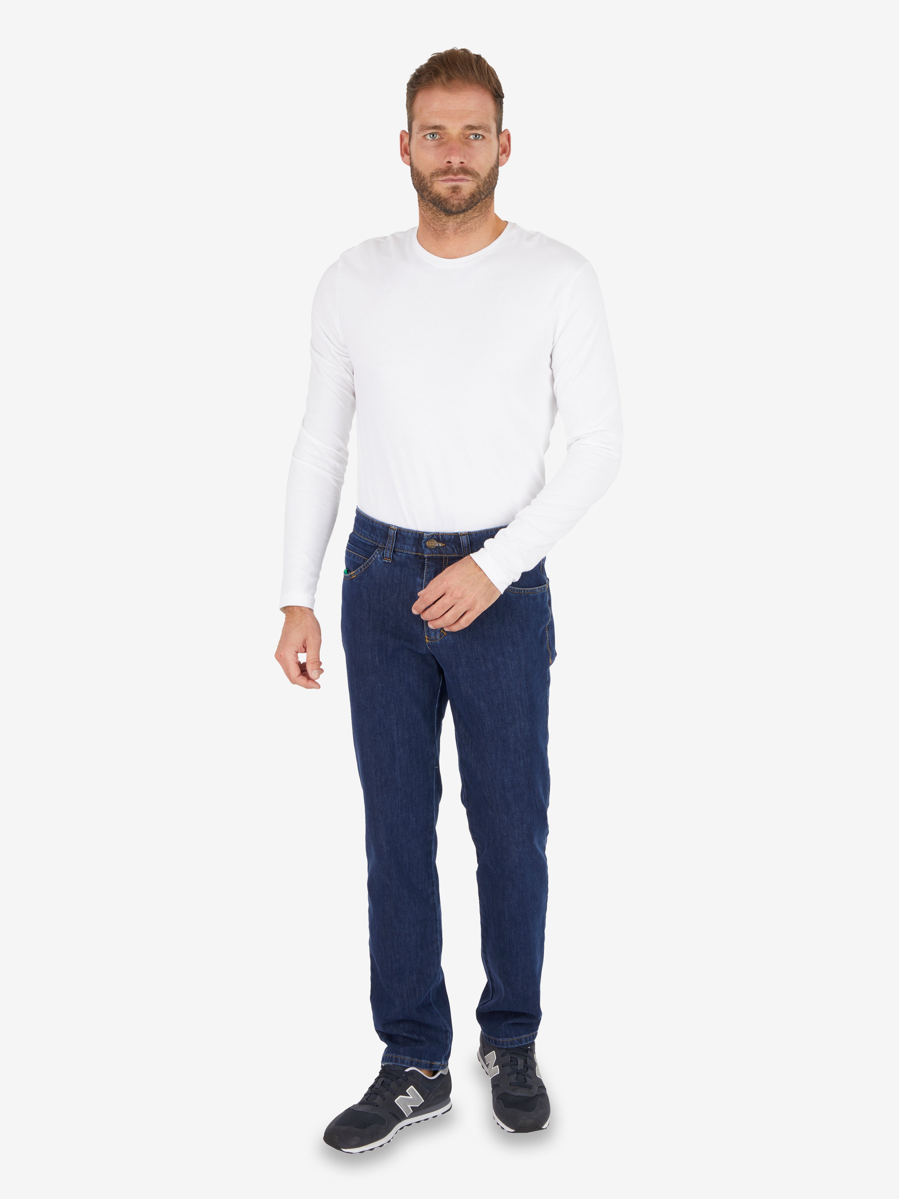 Ein Mann trägt eine weiße, langärmelige Pullover und eine dunkelblaue, elastische Jeanshose von Club of Comfort, Modell HENRY-Z7054 in jeansblau mit 6-Pocket-Design, elastischem Doppelstoffbund, Mobile Pocket, normalen Leibhöhe, schmalem Bein und Komfortbund.
