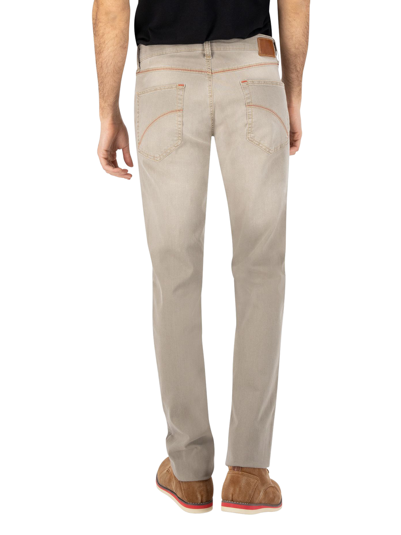 Ein Mann trägt hellbeige Jeans, die hinten zwei Taschen haben. Er trägt eine schwarze Oberbekleidung und braune Schuhe.