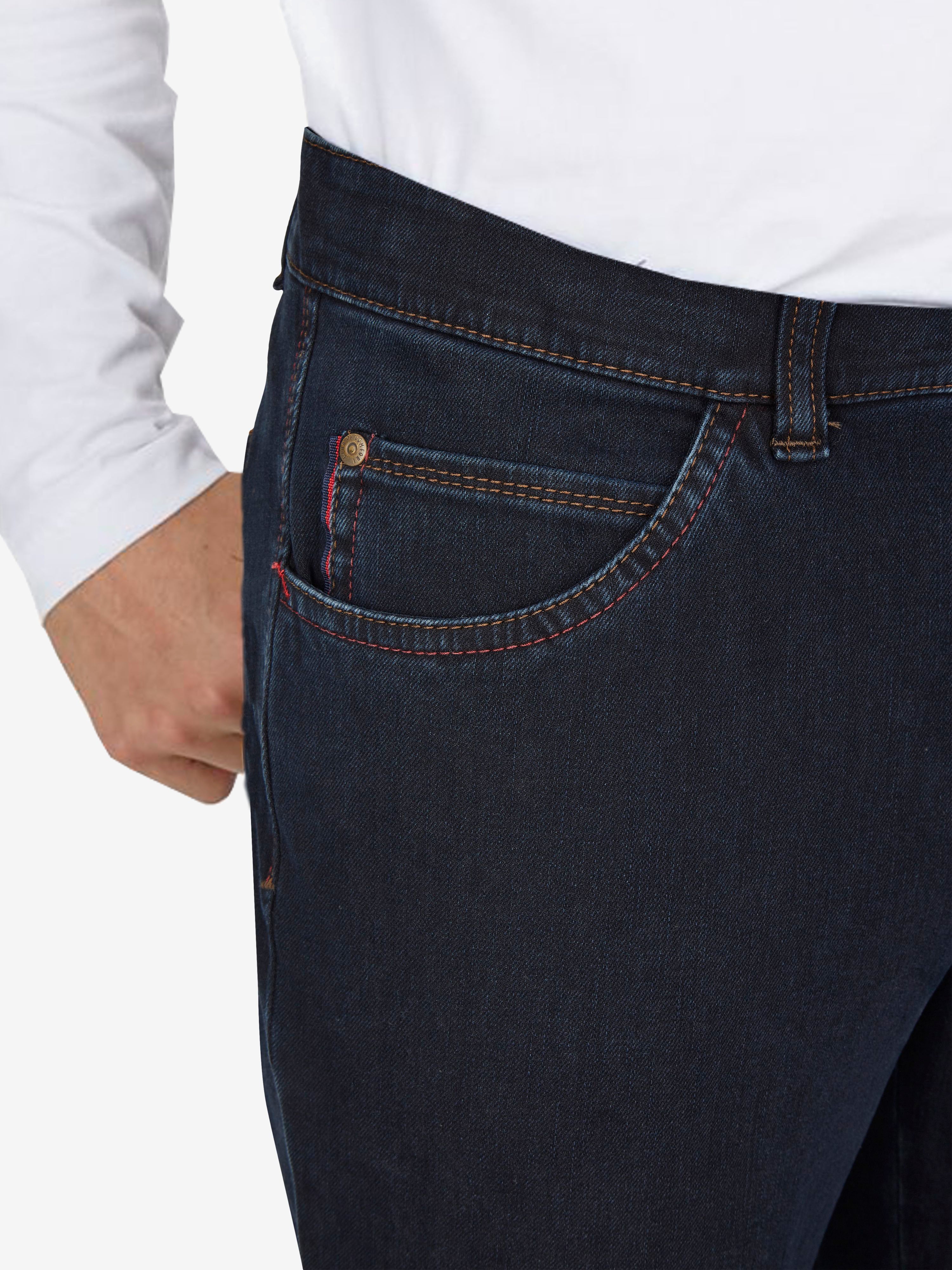 Nahaufnahme einer dunkelblauen, modifizierten 5-Pocket-Hose von Club of Comfort, mit Elastikbund, Hemdstopper, Swing-Pockets aus superelastischem Bi-Stretch-Denim, formstabil durch T400-Beimischung, Regular Fit, normaler Leibhöhe, an einer Person getragen.