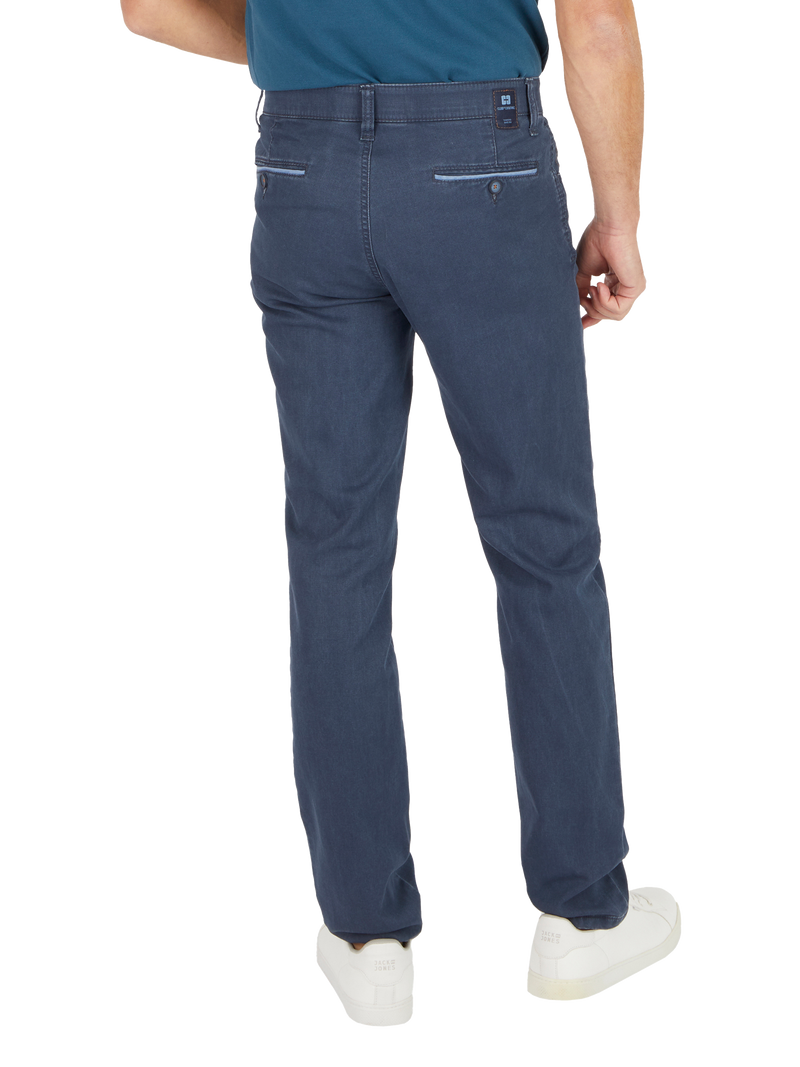 Ein Mann trägt dunkle Blue Jeans, die hinten eine kleine Tasche und eine Gürtel-Schlaufe haben.