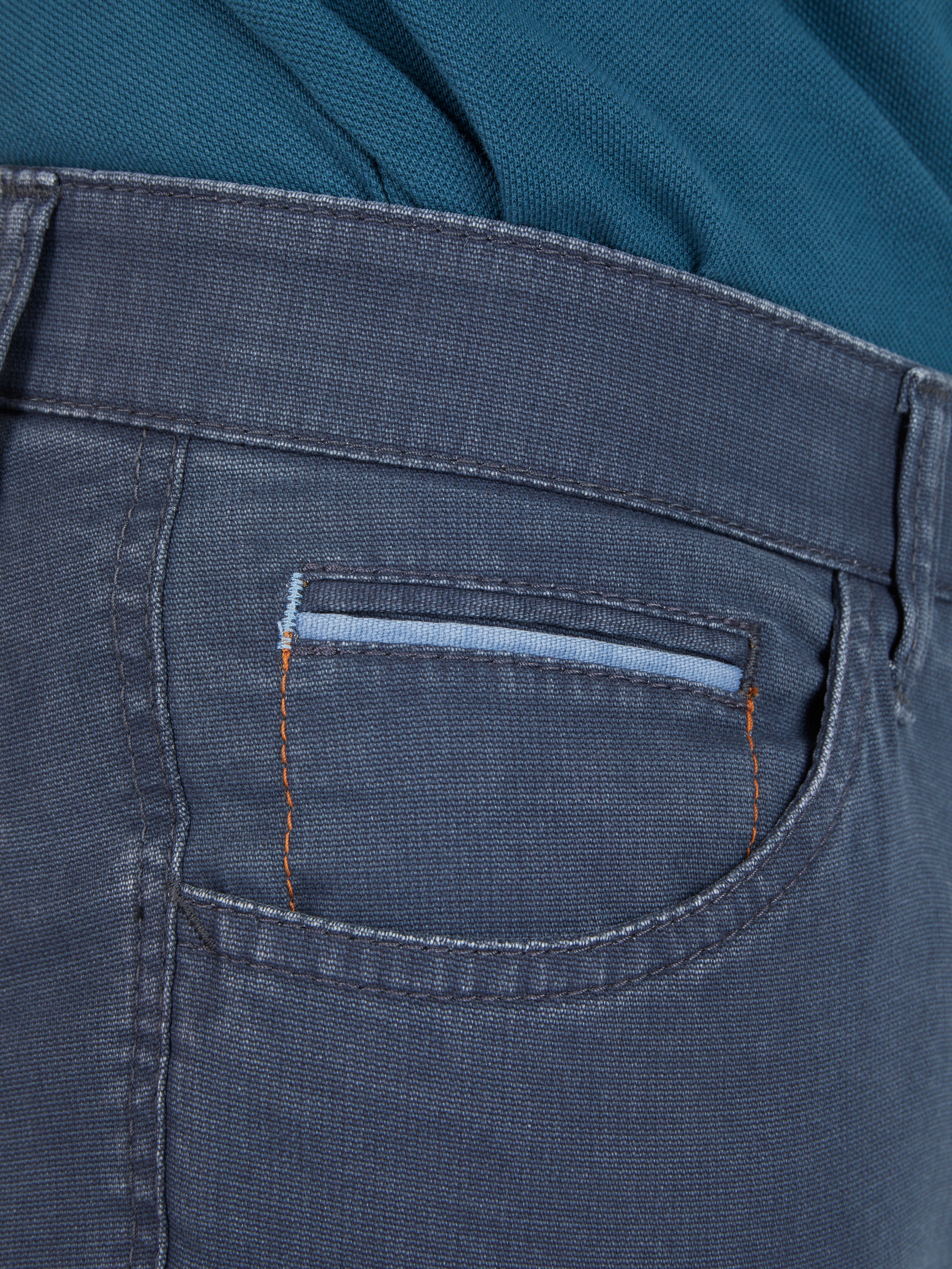 Nahaufnahme einer mittelblauen Hose "MARVIN 7506" von Club of Comfort mit elastischem Comfortbund, Hemdenstopper, doppelt paspelierter Münztasche mit Kontrast-Patch, aus High Stretch-Baumwolle in Mikrostruktur, mit schlanker Leibhöhe und schmalem Bein.