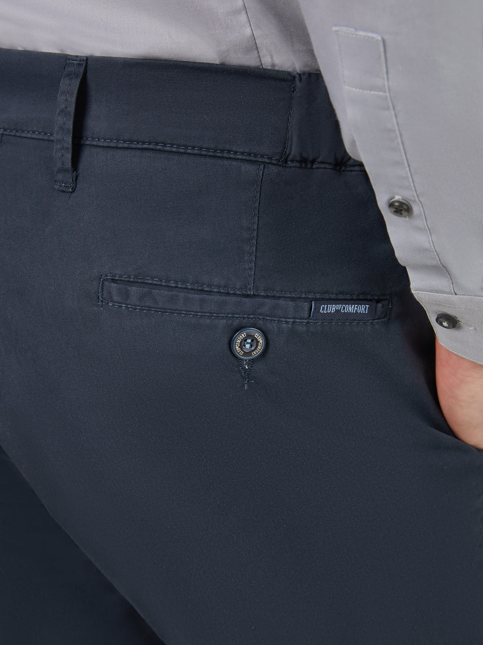 Nahaufnahme einer blauen, slim-fit Chino-Hose von Club of Comfort mit Comfort-Bund, Hemdenstopper, High Stretch Baumwolle, dezenter Rückentasche mit Label, hergestellt in Deutschland, geeignet für Frühling/Sommer.