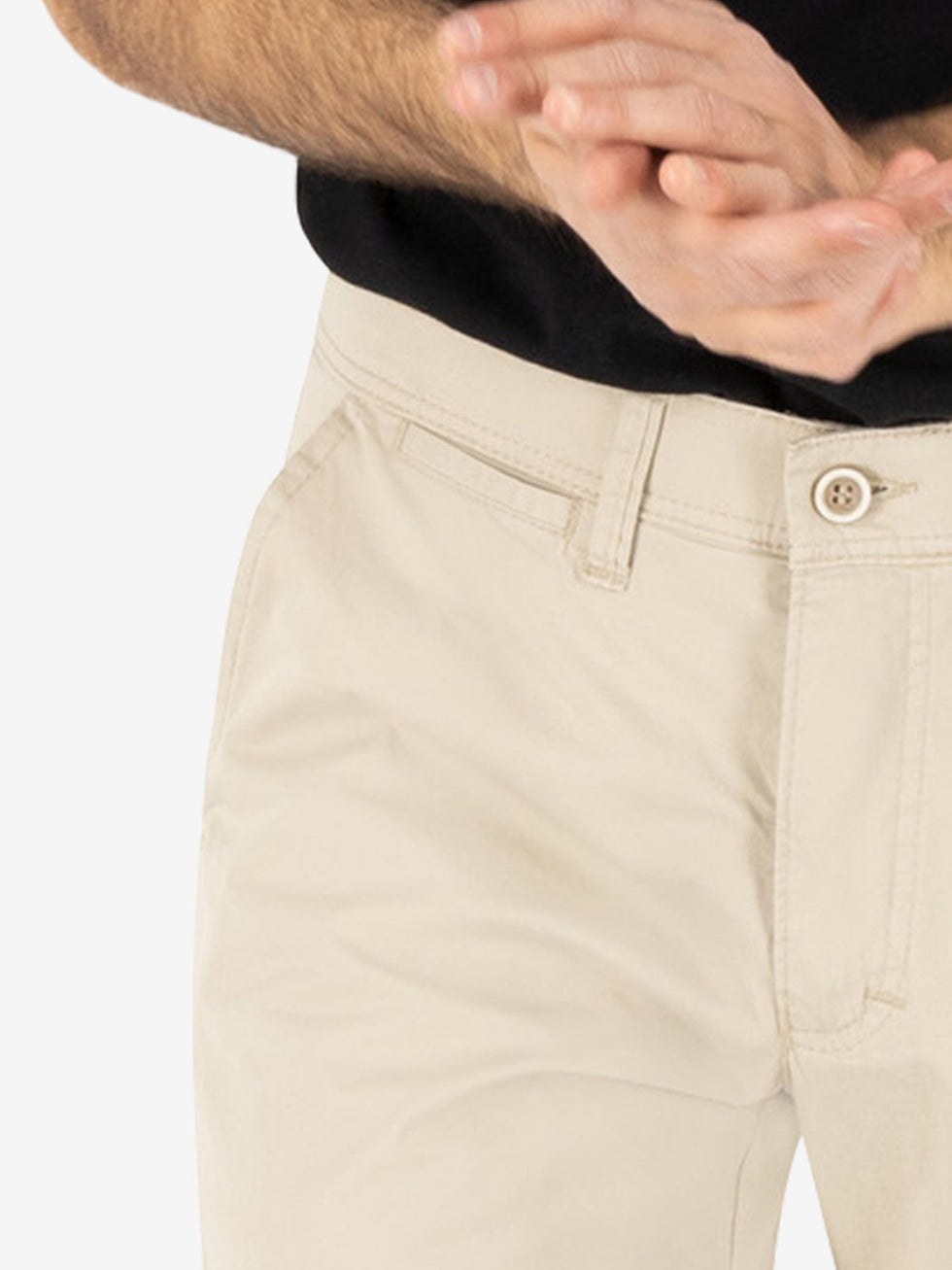 Nahaufnahme einer hellbeigen GARVEY 5107 Flat Front-Hose aus Baumwolle mit elastischem Komfortbund, Hemdstopper und schmaler Fußweite, getragen von einer Person in schwarzem Oberteil, geeignet für Frühling/Sommer.