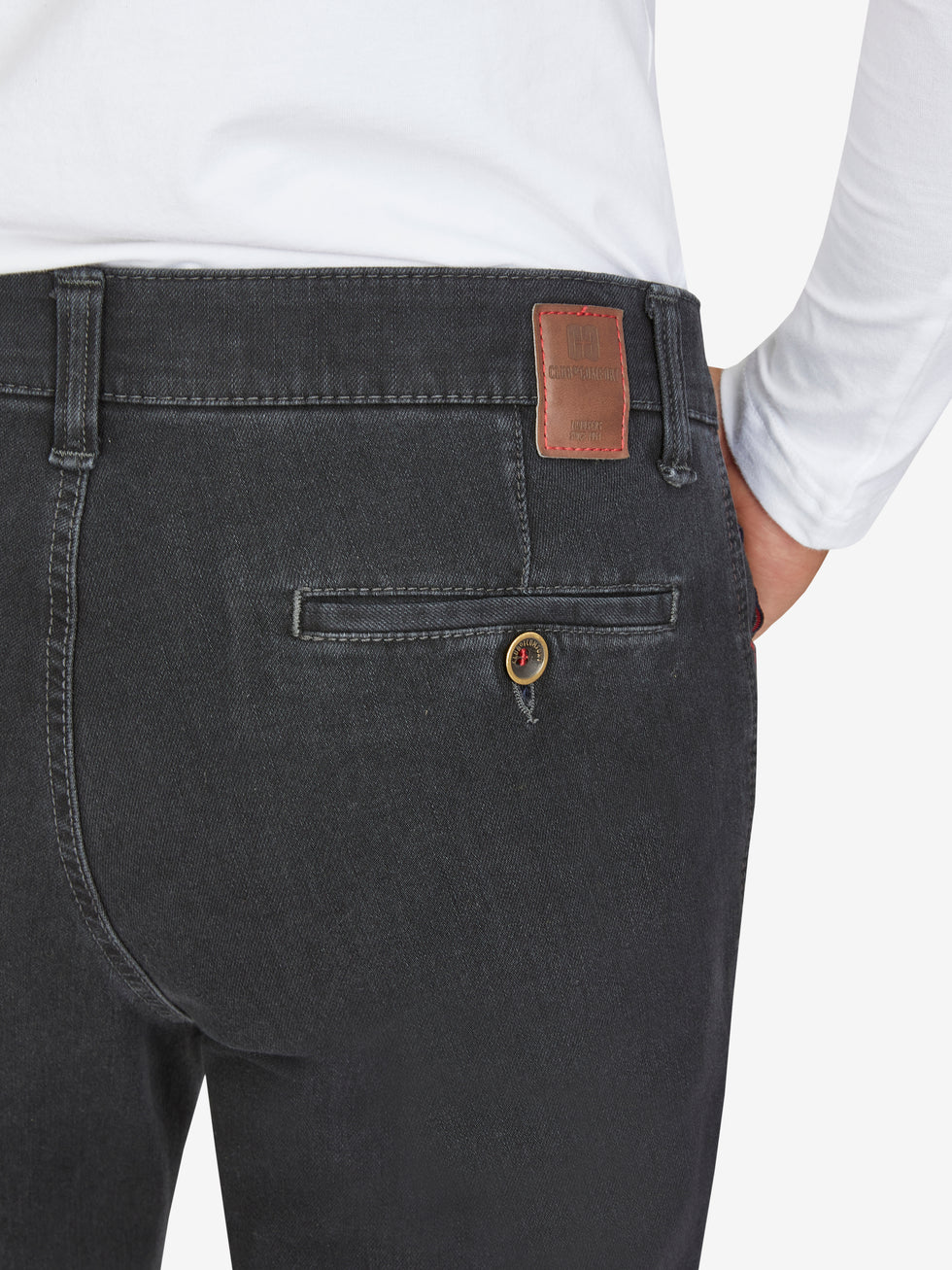Nahaufnahme einer schwarzen Hose (MARVIN 7054 - anthrazit) von Club of Comfort, mit elastischem Comfortbund, Swing-Pocket, modifizierter 5-Pocket-Design, aus superelastischem Bi-Stretch-Denim, formstabil durch T400-Beimischung, normaler Leibhöhe, schlankem Bein, auf weißem Hemd getragen.
